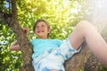 A 10 year old boy climbs a tree on a sunny day. Royalty Free Stock Photo