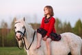 Small child is sitting in white pony thought and looking up Royalty Free Stock Photo
