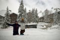 Small child on ski on mountain slope near smiling father and holding out hands. Background of snowy trees and houses Royalty Free Stock Photo