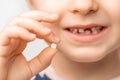 A small child smiles and holds a fallen baby tooth in his hand. Very close-up, soft light Royalty Free Stock Photo