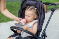 Toddler Drinking from Bottle in Stroller with Smartphone