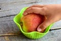 Small child takes a fresh peach in his hand. Sweet juisy peaches on a vintage wooden table. Natural food Royalty Free Stock Photo