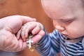 A child takes a rosary from his dad`s hand