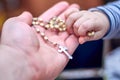A child takes a rosary from his dad`s hand