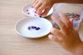 small child, toddler sorts small plastic chips by color, kid\'s fingers closeup, development fine motor skills, tactile Royalty Free Stock Photo