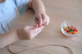 Small child, toddler stringing colored plastic beads on string, kid`s fingers close-up, concept of development of fine motor Royalty Free Stock Photo