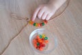 Small child, toddler stringing colored plastic beads on string, kid`s fingers close-up, concept of development of fine motor Royalty Free Stock Photo