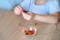 Small child, toddler stringing colored plastic beads on string, kid`s fingers close-up, concept of development of fine motor Royalty Free Stock Photo