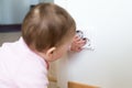 Small child touches an electrical outlet at home. Safety of children