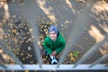 A small child is standing on the street and looking up. View from above. Royalty Free Stock Photo