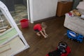 A small child washes the floors in the room with a wet rag, the concept of helping parents and child labor.