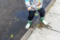 a small child wearing wellies or wellington boots splashing in puddles Royalty Free Stock Photo