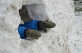 A small child in winter coveralls walks will build an igloo. little boy sticks his hands out of an ice cave, hole, house. He has g Royalty Free Stock Photo