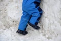 A small child in winter overalls walks will build an igloo. little boy climbs the roof. on the ice wall, glaciers in coveralls. hi