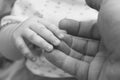 Small child's hand in hand of adult parent closeup / black and white photo in retro style