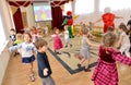 Small children dance together with clowns-animators. A holiday in kindergarten