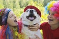 Small children dressed in elegant festive fun wigs with their dog