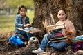 Small children with hand loom sitting outdoors in city park, learning group education concept.