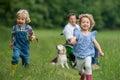 Small children with senior grandfather in wheelchair and dog on a walk on meadow in nature. Royalty Free Stock Photo
