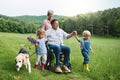 Small children with senior grandparents and dog on a walk on meadow in nature. Royalty Free Stock Photo