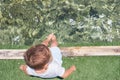 Small children sitting on the wooden pier in the water and enjoying summer day. Bare feet of boy. Vacation by the sea Royalty Free Stock Photo