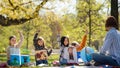 Small children with teacher outdoors in city park, learning group education and art concept.