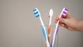 Small childs hand reaches for toothbrush in glass, going to brush teeth, hygiene