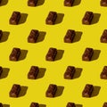 Small chocolate bar on a yellowt background. seamless pattern. Background image. Hard shadow. Top view, flat lay Royalty Free Stock Photo
