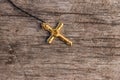 Small Christian golden cross on rustic wooden background Royalty Free Stock Photo