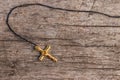 Small Christian golden cross on rustic wooden background Royalty Free Stock Photo