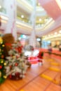 Small Christmas tree and decorations in a shopping mall at blurred focus vertical composition as background Royalty Free Stock Photo