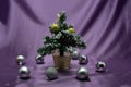 A small Christmas tree in a pot, decorated with balls, garlands and lights. Royalty Free Stock Photo