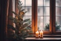 a small christmas tree sits in front of a window Royalty Free Stock Photo