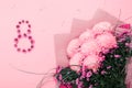 Small chrysanthemums in the shape of a heart and a large bouquet of lush flowers on bright pink background with copy space.