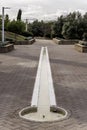 A small circular fountain at ground level with a small elongated pool filled with water Royalty Free Stock Photo