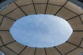 a small circular skylight at an airport lobby with clouds in the background Royalty Free Stock Photo