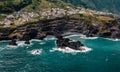 Small city Seixal on cliff, Atlantic ocean coastline. Empty beach, sea foam and waves. Madeira island, Portugal. Aerial Royalty Free Stock Photo