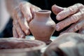 Small clay vase and hands of working potter Royalty Free Stock Photo