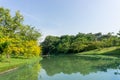 A small clean lake in public park, greenery trees, shrub and bush, green grass lawn in a good care maintenance landscapes Royalty Free Stock Photo