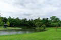 A small clean lake in public park, greenery trees, shrub and bush, green grass lawn in a good care maintenance landscapes, under