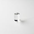 A small, clear, cylindrical glass object is placed on a smooth Royalty Free Stock Photo