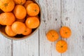 Small clementine oranges in a stainless-steel bowl