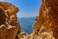 Small cliff rocks at Algar Seco with the view of boats sailing on Atlantic ocean