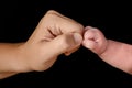 Small closed hand of newborn baby bumping his fist with his mother`s hand. Royalty Free Stock Photo