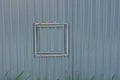 Small closed square door on a gray metal fence