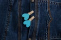 Small clothespins with blue hearts on the pocket of blue jeans Royalty Free Stock Photo