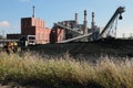 A Small Coal Fired Power Plant with Coal Yard and Wildflowers. Royalty Free Stock Photo