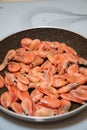 Small cocktail shrimps are fried in a pan. Royalty Free Stock Photo