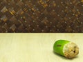 Small coconut isolated on table in weave background