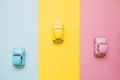 Small color toy cars on a yellow, pink and blue background. Business competition, winners and losers. Finish line Royalty Free Stock Photo